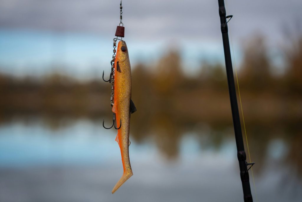 Fishing lure with treble hooks hanging from rod